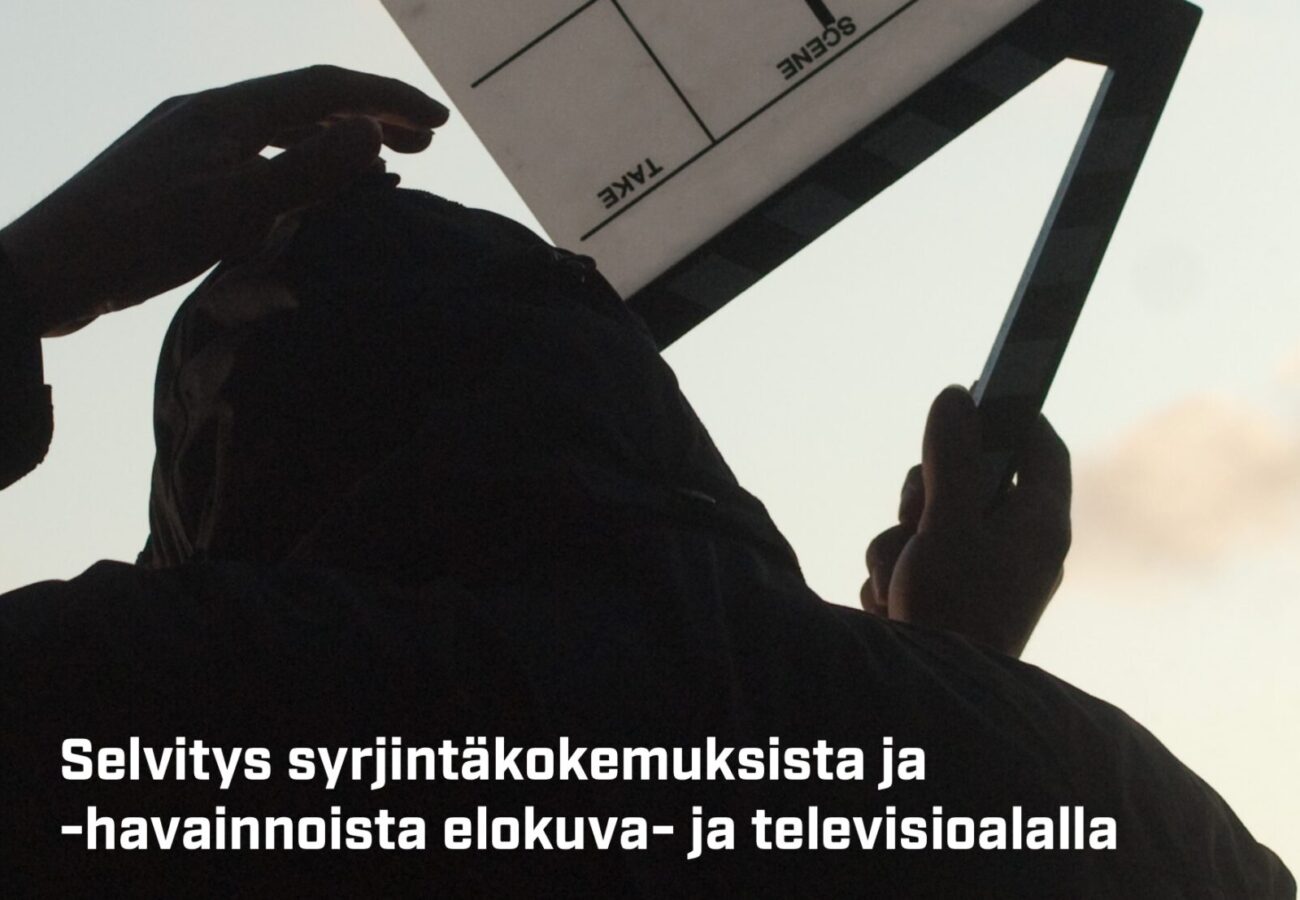 Elokuva- ja tv-työntekijän silhuetti pitää klaffia ylhäällä.